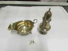 A silver sugar caster and a silver sauce