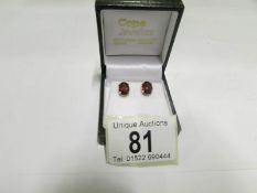 A pair of 9ct gold garnet stud earrings