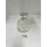 A cut glass silver topped perfume bottle