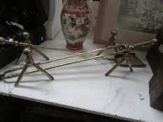 A set of brass fire irons and fire dogs