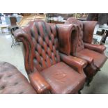 A pair of leather wing arm chairs