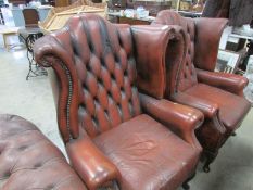 A pair of leather wing arm chairs