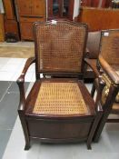 A mahogany commode with can seat and bac