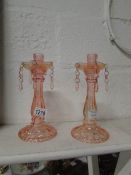 A pair of glass candlesticks with droppe