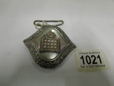 A belt buckle for an usher at the houses
