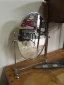 A chromed swivel toilet mirror