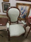 A mahogany framed chair with green uphol