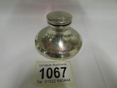 A silver capstan ink well