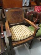 An elbow chair with tooled leather back