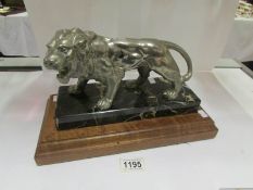 A lion figure on wood and marble base