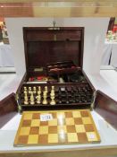 A Victorian rosewood games box containin