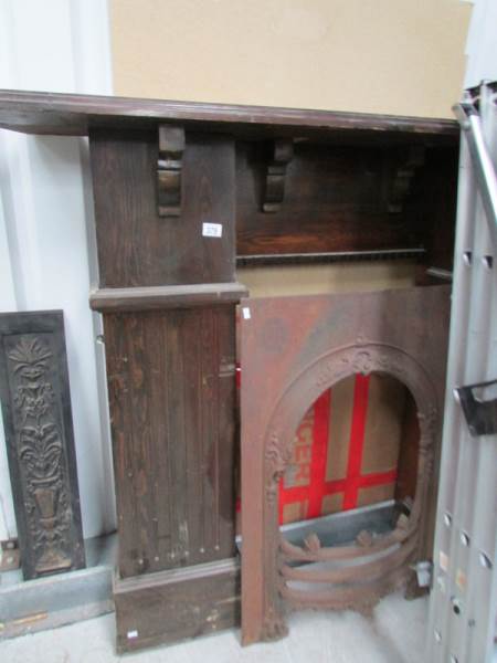 A wooden fire surround with cast iron in