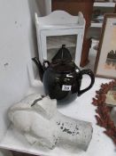 A large teapot, a bust and a small cabin