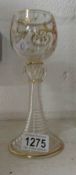 A gold decorated wine goblet on ribbed s
