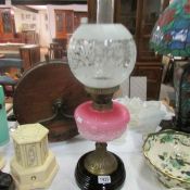 An oil lamp with pink glass a/f font and etched shade