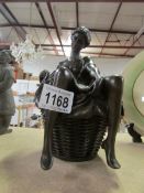 A bronze figure of a female in a bath tub