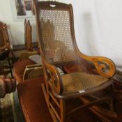 A beech framed rocking chair with rattan seat and back and leaf motif