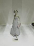 A Lladro figure of a lady with bow