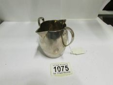 A silver twin lipped cream jug