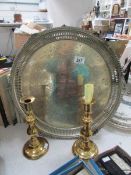 A large metal commemorative tray and a pair of brass candlesticks