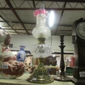 An oil lamp with shade and with maker's mark to brass base
