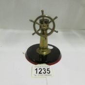 A brass cigar cutter in the shape of a ship's wheel