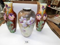 A pair of hand decorated vases and one other