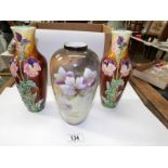 A pair of hand decorated vases and one other