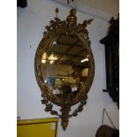 An antique gilt framed mirror surmounted cherub
