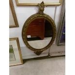 An oval gilt framed mirror