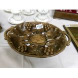 An Arts and Crafts carved wooden dish depicting fruit and flowers