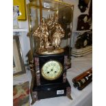 A black marble clock surmounted gilded spelter figures