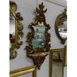 An ornate gilt framed mirror with shelf,