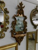 An ornate gilt framed mirror with shelf,