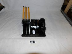 A set of bakelite handled fruit knives on a wooden stand with bear