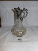An early 20th century claret jug with a pewter handle,