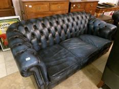 A green leather Chesterfield sofa
