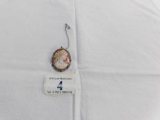 A cameo shell brooch with safety chain