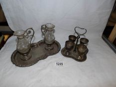 A silver plated egg cup stand plus oil and vinegar bottles on tray
