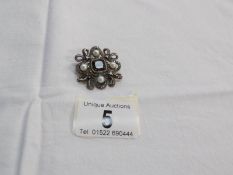 A silver brooch/pendant set seed pearls with smoky quartz centre