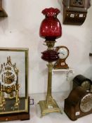 A brass Corinthian column oil lamp with ruby glass font and shade