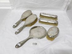 6 silver backed brushes and a silver backed hand mirror