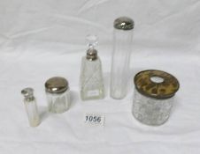 4 silver rimmed bottles and a silver topped hair pot