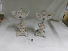A pair of continental porcelain bowls supported by cherubs
