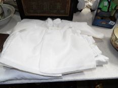 A quantity of linen nightgowns and a baby coat