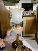 A Victorian oil lamp with brass column and mottled peach glass font