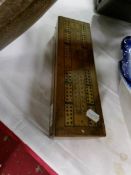 A box with cribbage board top containing dominoes and draughts