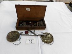 A cased set of Victorian hand balance scales with some weights