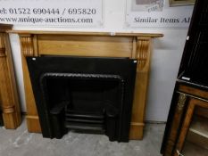 A Georgian style cast iron fire place with pine surround