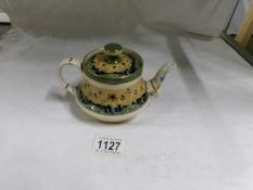 A Macintyre teapot circa 1902, Duraware raised slipware design of poppies, stamped Macintyre,
